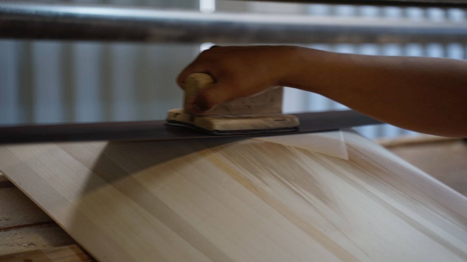 Artisan hand-sanding a hardwood casket lid at the Fontana factory
